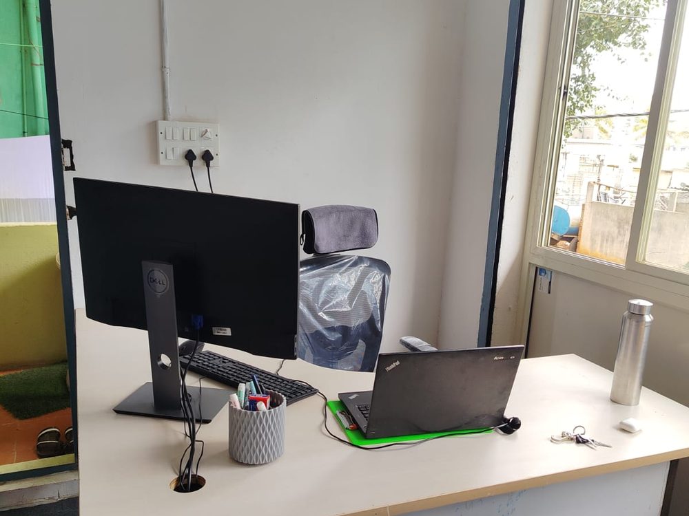 The front office desk with a monitor and laptop, beside a window.